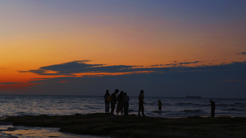 余晖夕阳落日傍晚夜景海边游玩人物