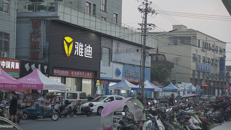夏天夜晚电动车电瓶车马路店铺街道