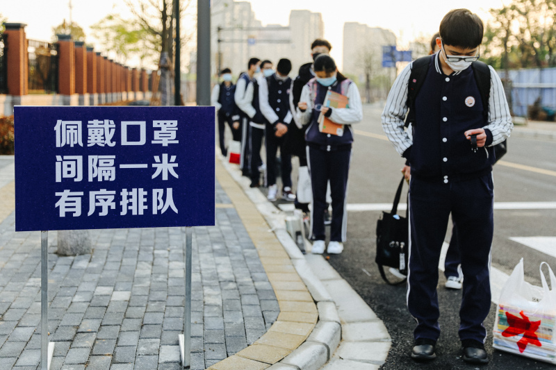 余姚疫情后开学学生戴口罩排队测温上学
