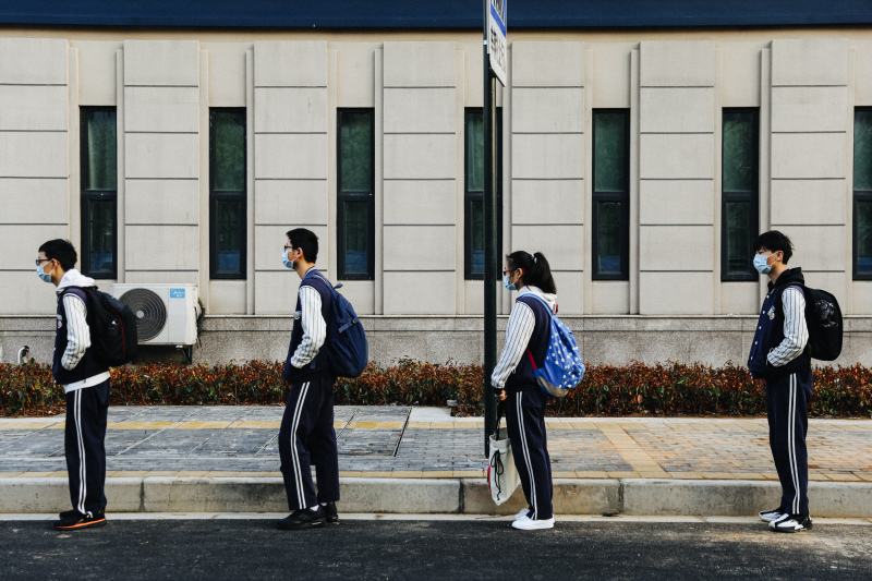 余姚疫情后开学学生戴口罩排队测温上学