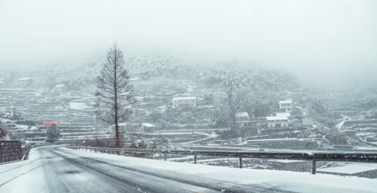 余姚四明山道路雪景山路山间下雪茶叶山交通蜿蜒航拍俯瞰大山里乡村房子